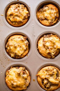 six muffins in a pan with cheese and meat toppings on the top