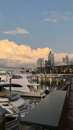 the boats are docked in the harbor by the city buildings and water at sunset or dawn