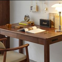 a wooden desk topped with a lamp next to a chair