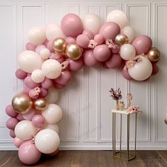 the balloon arch is decorated with pink, white and gold balloons