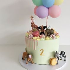 there is a cake with animals and balloons on the top of it that says 2