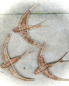 two pieces of wire sitting on top of a cement floor next to pins and needles