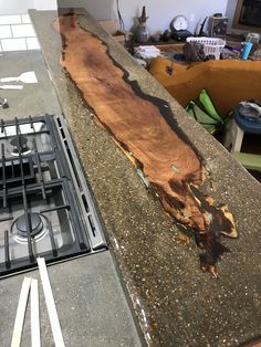 a large piece of wood sitting on top of a kitchen counter next to a stove