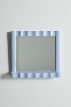 a blue mirror mounted to the side of a wall