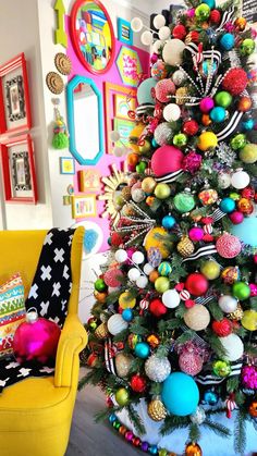 a brightly colored christmas tree in a living room with colorful ornaments on the top and bottom