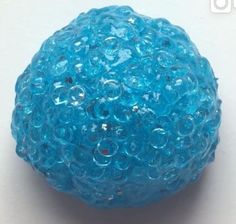 a blue ball with bubbles on it sitting on a white surface, in the foreground