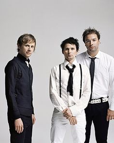 three men standing next to each other in white shirts and ties