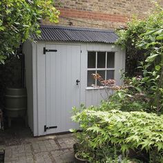 a garden shed in the middle of some plants