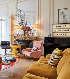 a living room filled with lots of furniture and a large mirror on the wall above it