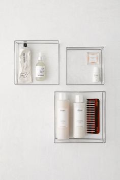 three clear boxes with different items in them on a white surface, including a comb and lotion