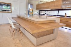 a modern kitchen with an island counter and chairs