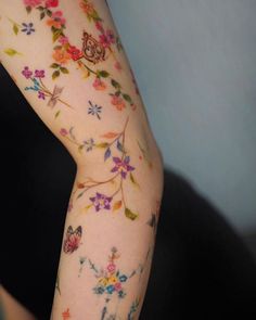 a woman's arm with flowers and butterflies on it