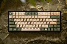 a computer keyboard sitting on top of a brown paper covered surface with trees in the background