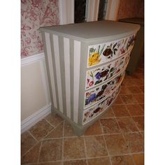 a dresser with flowers painted on it in a room next to a door and tile floor