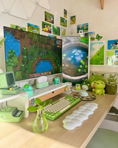 there is a computer on the desk with many pictures and plants in front of it