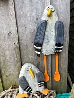 two birds made out of wooden spoons sitting on top of rope