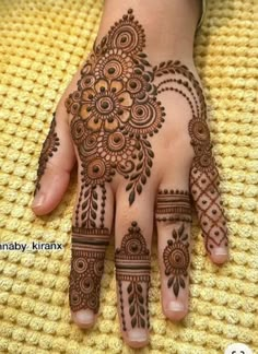 henna tattoo on the palm of a woman's hand, with intricate designs