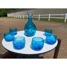 a table with blue glasses and a bottle on it