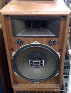 an old wooden speaker sitting on top of a shelf next to other audio equipment in a store