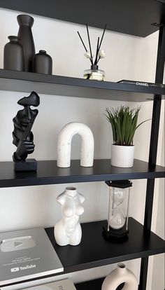 shelves with vases, books and other items on top of them in a room