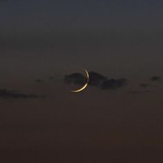 the moon is shining in the night sky with clouds and some dark blue hues