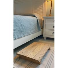 a wooden table sitting on top of a rug next to a bed