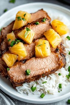 pork with pineapples and white rice on a plate