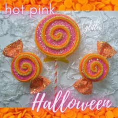 there are three lollipops on top of the lace tablecloth, one is pink and orange