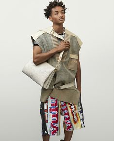 a young man is holding a white bag