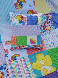 there is a colorful patchwork quilt with teddy bears and rainbows on the squares