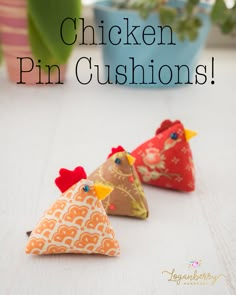 three chicken pin cushions sitting on top of a table