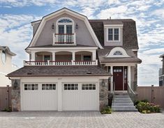 a large house with two garages on the front and second story, surrounded by brick pavers