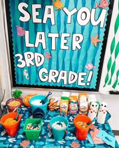 a table topped with lots of food next to a sign that says sea you later 3rd grade