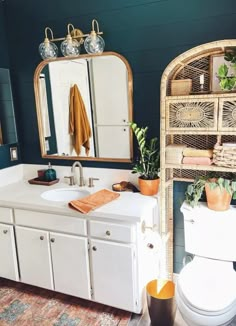 a bathroom with a toilet, sink and mirror in it's centerpieces