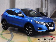 a blue nissan suv parked in a garage