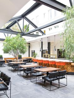 tables and chairs are lined up in an open area with black leather seats on them