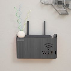 a wall mounted wifi device on the side of a white wall next to a clock