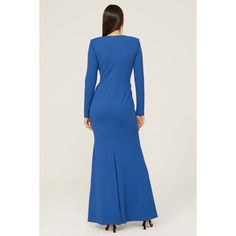 a woman in a long blue dress is looking back at the camera and she has her hands on her hips