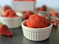 two small bowls filled with ice cream and strawberries on the table next to each other