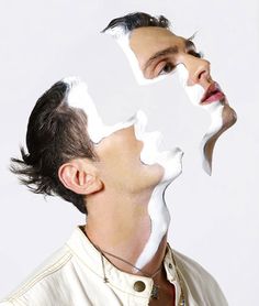 a man with white facial mask on his face looking up at the camera while standing in front of a white background