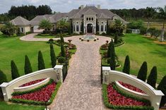 an aerial view of a large home in the middle of a lush green yard and driveway