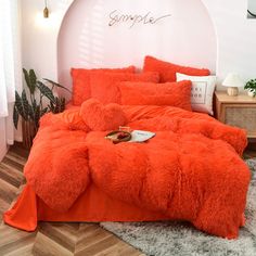 an orange comforter set on a bed in a room