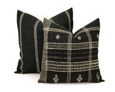 two black and white pillows sitting next to each other