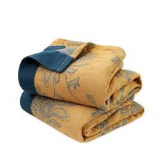 three folded towels on top of each other with blue and yellow designs in the middle