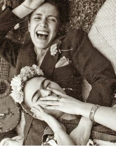 an old black and white photo of a woman laughing with her hands on her face