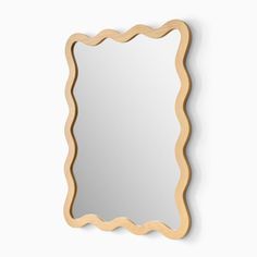 a mirror that is on the wall with a scalloped edge and a wooden frame