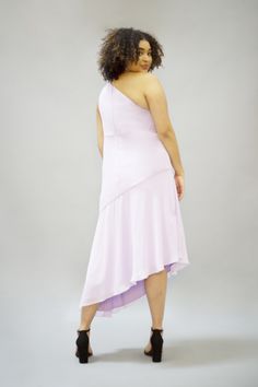 a woman in a pink dress is posing for the camera with her hands on her hips