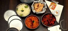 a table topped with different types of food next to silver containers and utensils