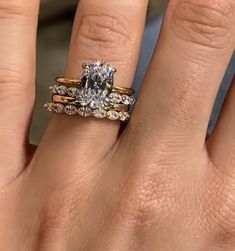 a woman's hand with two rings on it and a diamond in the middle