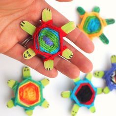 a hand is holding a small crochet tortoise with four smaller turtles in the background